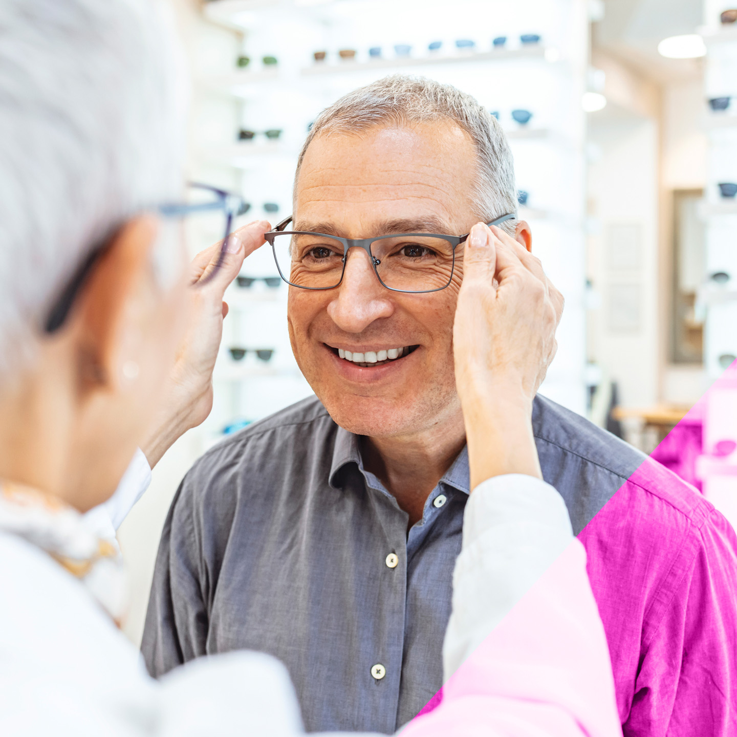 an elderly man tries on a new pair of glasses