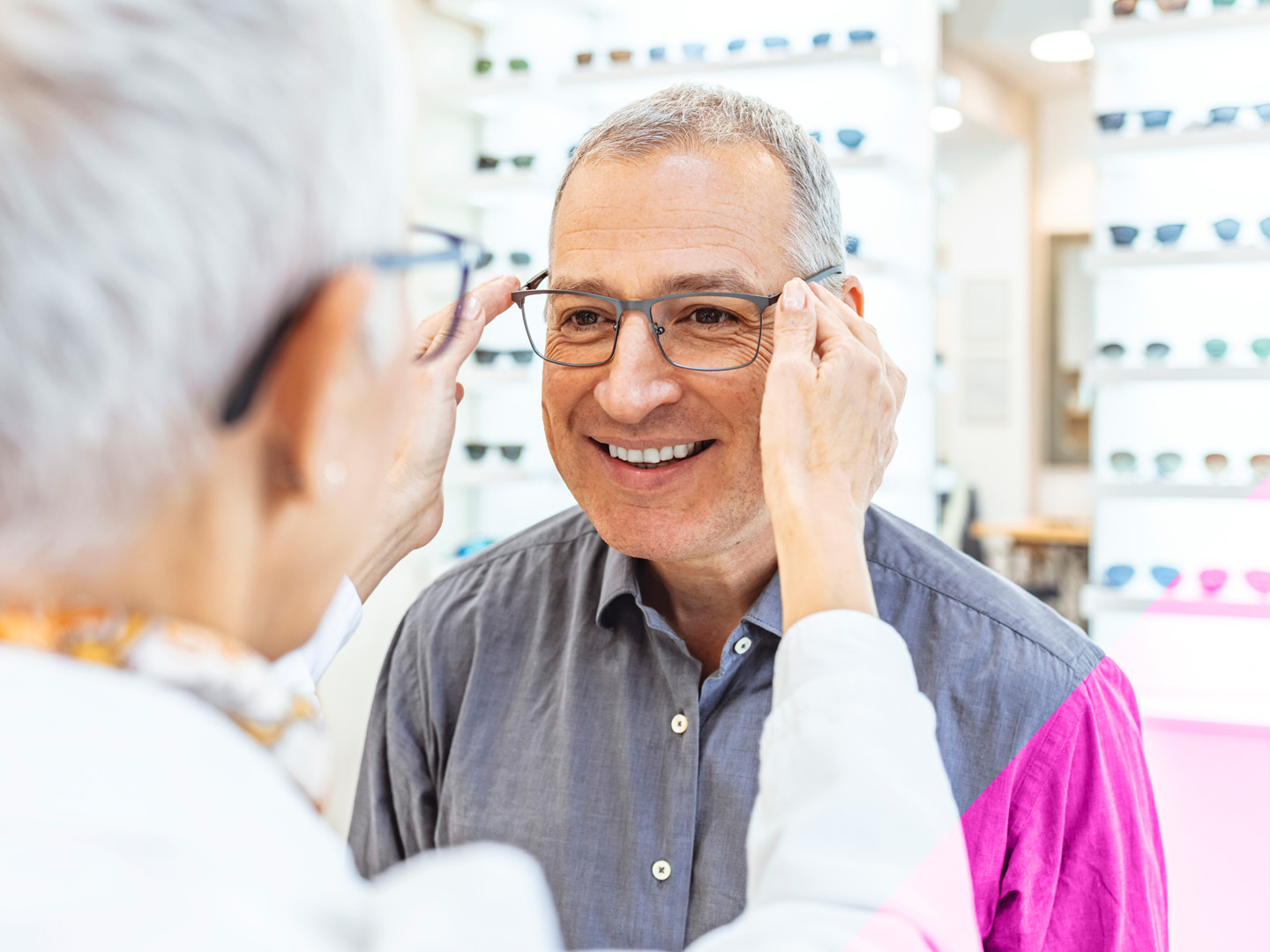 an elderly man tries on a new pair of glasses