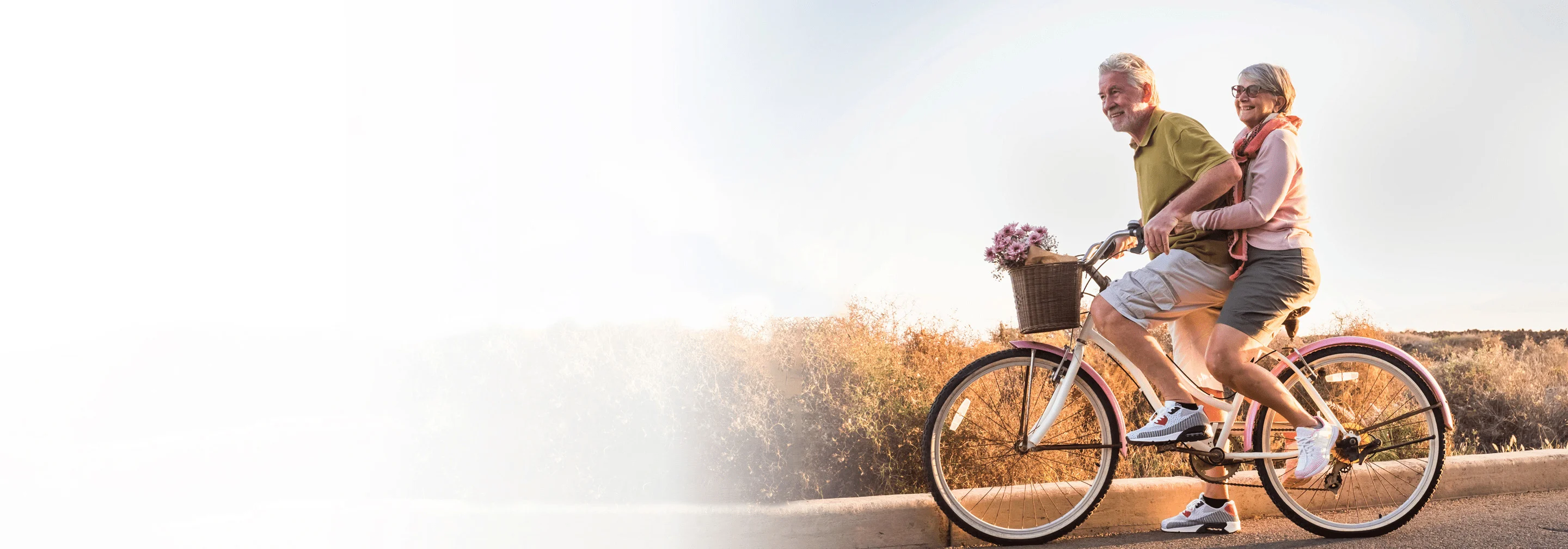 elderly couple rides tandem bicycle and smiles