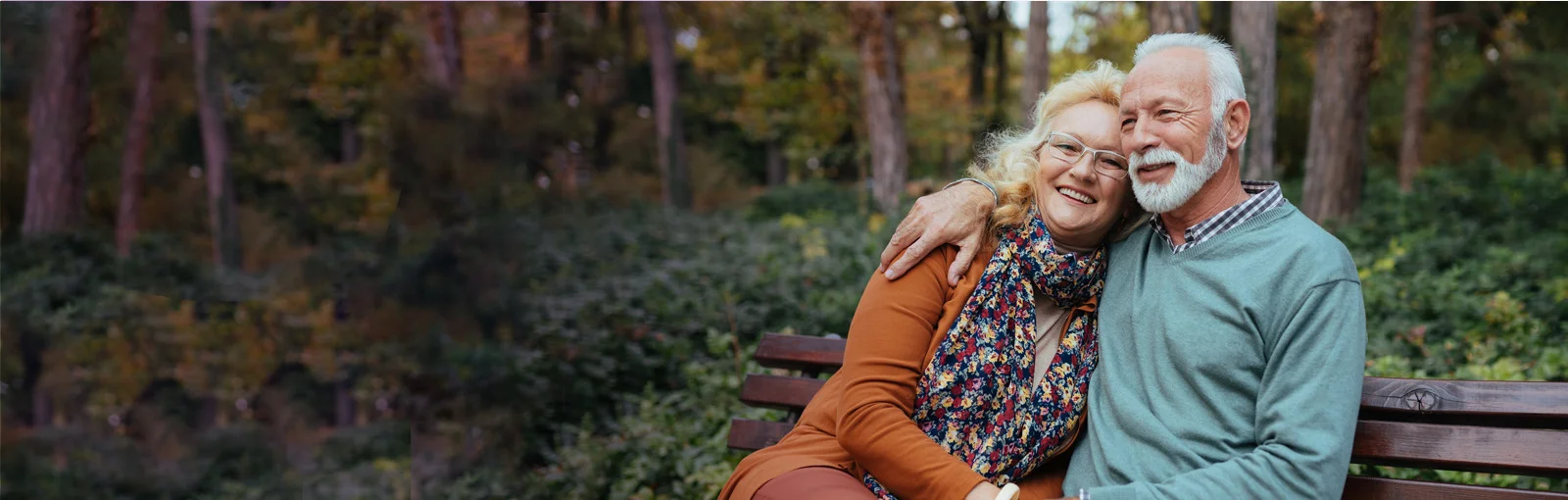 elderly couple sitting on park bench