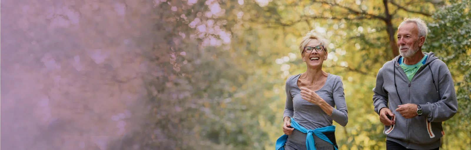 elderly couple go jogging on park trail